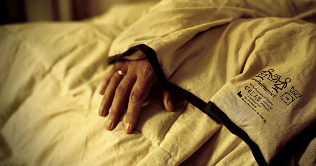 Voksen person sover roligt med en RestfulBlanket® tyngdedyne