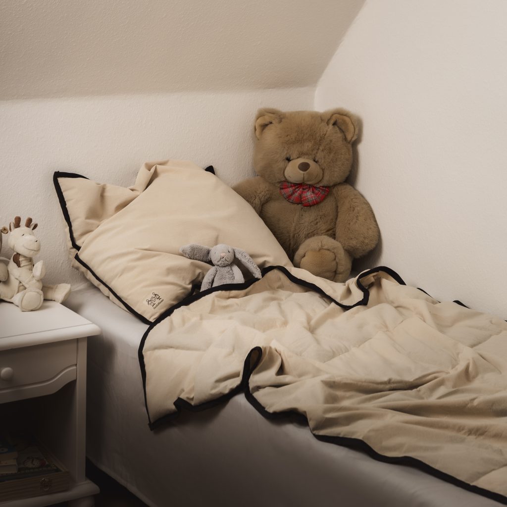 Naturlig junior tyngdedyne fra RestfulBlanket lagt i barneseng med bamser som eksempel på tryg tyngdedyne til boern